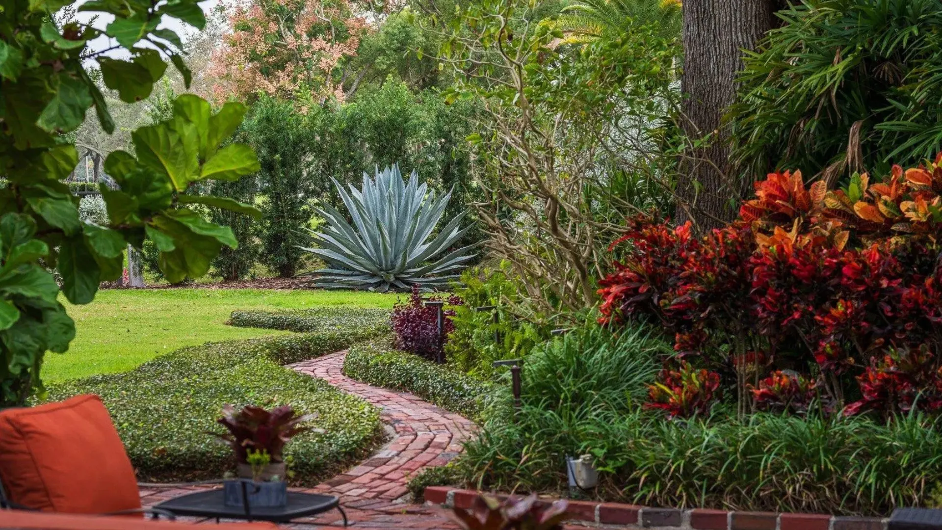 Traditional landscaping style with curved beds, colorful plants, and lush garden design
